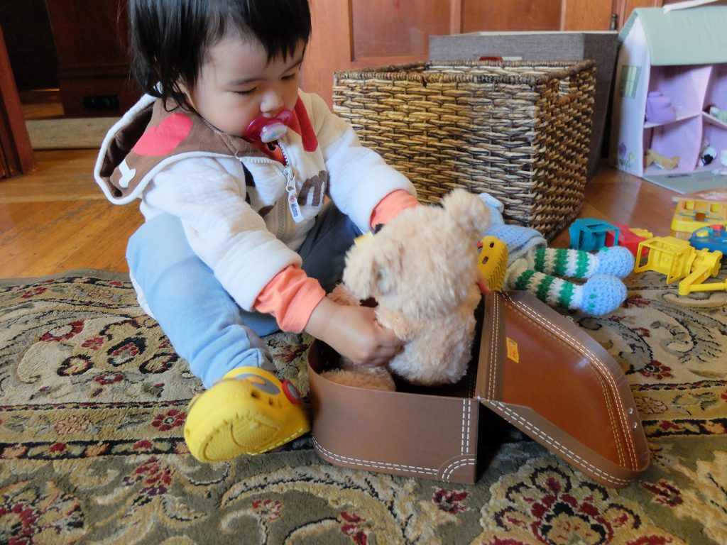 toddler packing the teddy bear