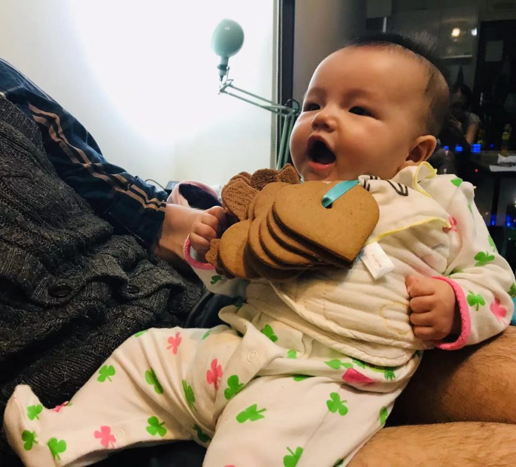 baby with cookies around the neck